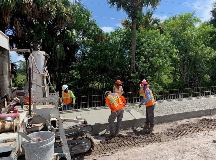 Concrete crew finishing slipform class II conctrete pour for barrier wall coping junction slab located on SR 710 Warfield Blvd at SW Tommy Clements Street, August. 2024
