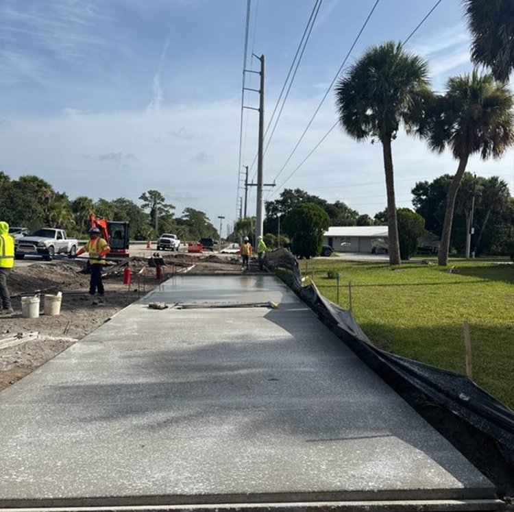 The contractor placing concrete sidewalk, July 2025